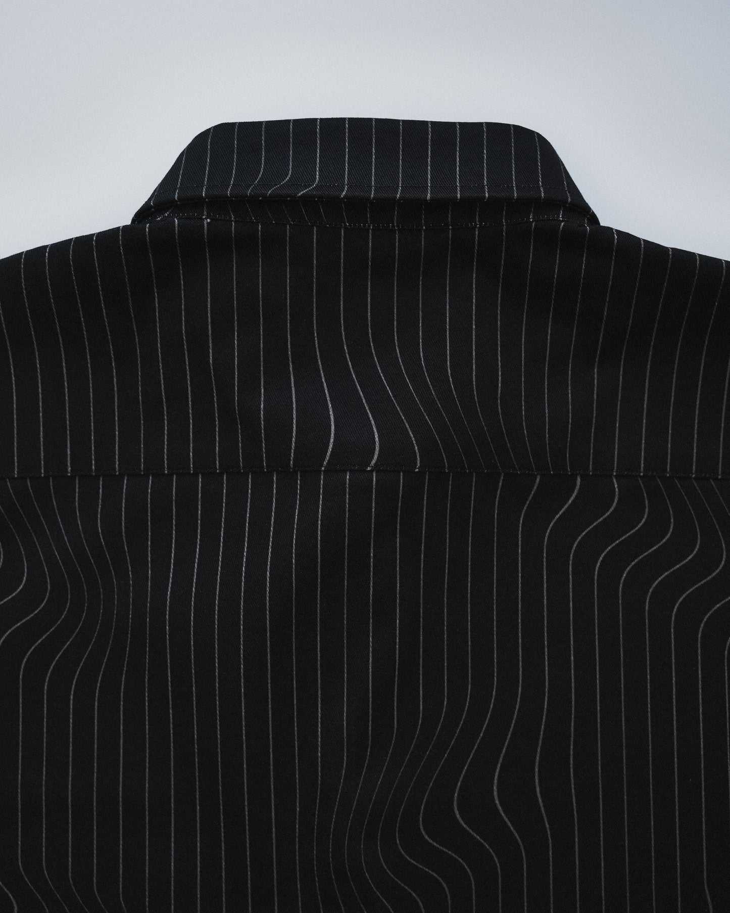 Close-up of a black pinstripe shirt on a white background