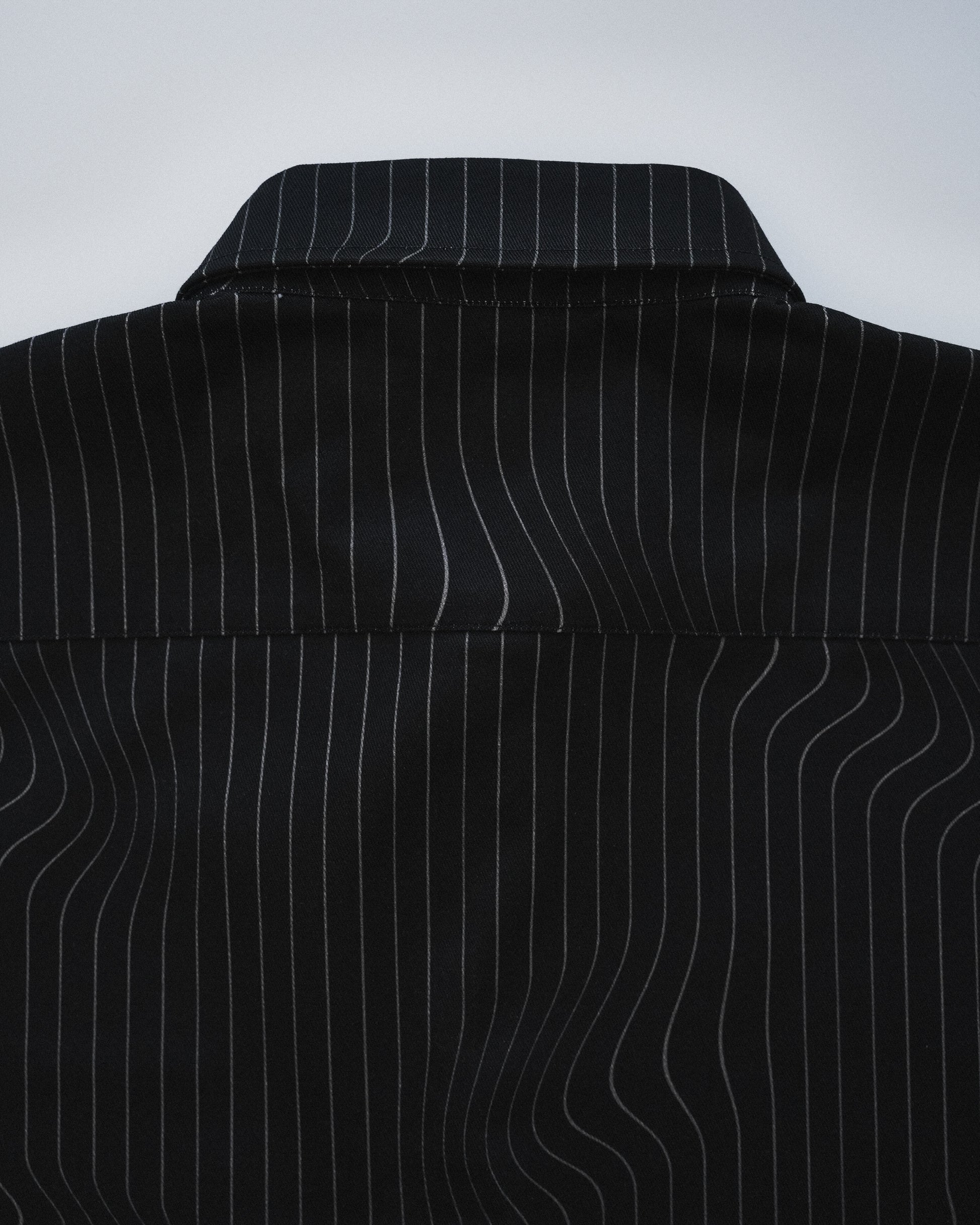Close-up of a black pinstripe shirt on a white background