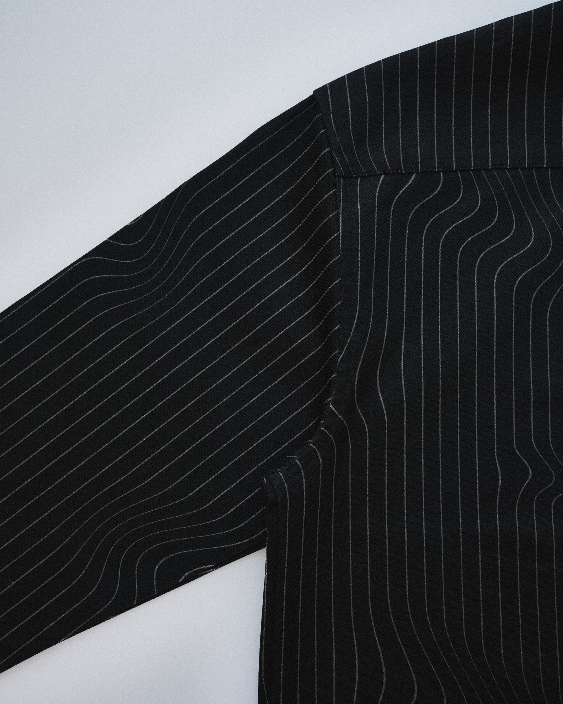 Close-up of a black pinstripe shirt on a white background